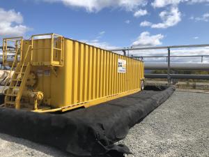 yellow frac tank inside containment